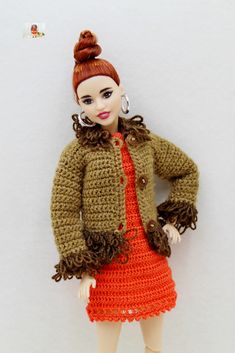 a doll is wearing an orange dress and jacket