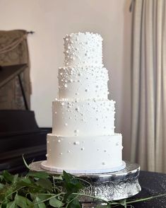 a white wedding cake sitting on top of a table