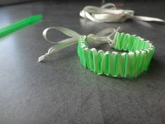 two green bracelets sitting on top of a table next to a pair of scissors