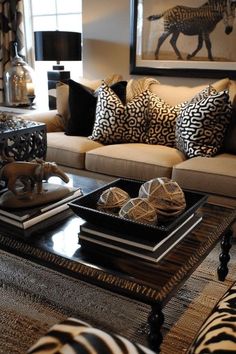 a living room with zebra print pillows on the couches and coffee table in front of it