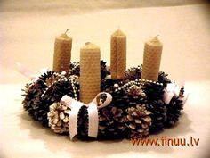 a pine cone wreath with candles on it