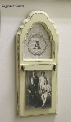 an old photo hanging on the wall above a frame with a family picture in it