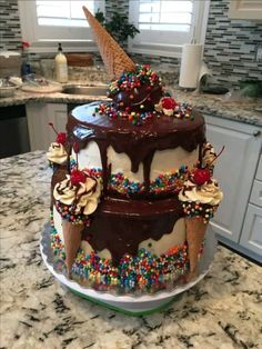 a three tiered cake with ice cream and sprinkles on the top