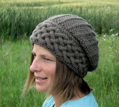 a woman wearing a knitted hat standing in the grass