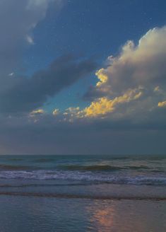 the sky is full of stars and clouds over the ocean at sunset or sunrise time