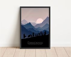 the lord of the rings minimalist movie poster in black frame on wooden floor against white wall