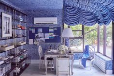 a room with blue and white decor in the walls, windows, and shelves filled with books