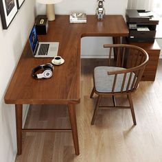 a wooden desk topped with a laptop computer next to a lamp and pictures on the wall