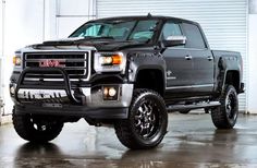 a black truck parked in front of a garage door