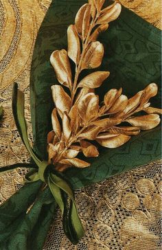 a green napkin with gold leaves on it