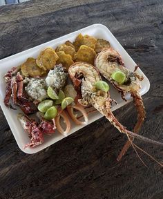 a white plate topped with lots of food on top of a wooden table