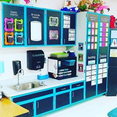 a kitchen area with blue cabinets and white counter tops, including a coffee maker on the wall