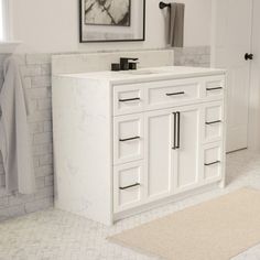 a bathroom with white cabinets and marble counter tops, along with a rug on the floor