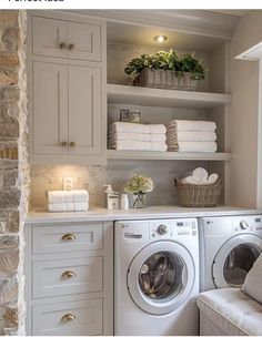 a washer and dryer sitting in a room next to each other with towels on top of them