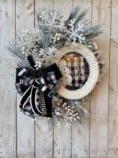 a christmas wreath on a wooden wall with snowflakes and pineconis around it