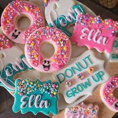 decorated doughnuts with donuts and sprinkles are displayed on a platter