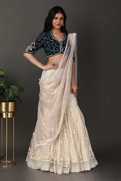 Off-white lehenga with a detachable drape having beads and thread hand embroidered borders. Comes with a navy blue jaal work padded blouse. - Aza Fashions Fitted Pre-draped Saree With Zari Work For Wedding, Fitted Pre-draped Saree With Resham Embroidery In Raw Silk, Fitted Dola Silk Saree With Dori Work, Raw Silk Sharara With Unstitched Blouse For Reception, Traditional Drape Sharara With Resham Embroidery For Reception, Fitted Dola Silk Pre-draped Saree With Dori Work, Elegant Traditional Drape Choli For Diwali, Elegant Chanderi Lehenga With Traditional Drape, Elegant Chanderi Lehenga In Traditional Drape