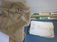 there is a bag that has two blocks written on it and some pens next to it