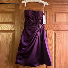 a purple dress hanging on a wooden door