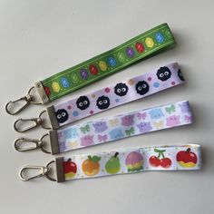 four key fobs are lined up on a white surface with an animal theme