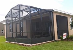 a house with a screened porch in the grass