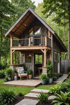 a small wooden cabin in the middle of some trees and grass with stairs leading up to it