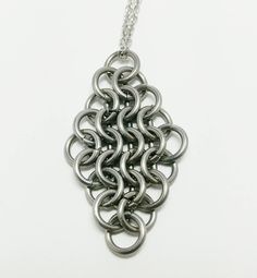 A piece of history for you to wear every day! This pendant uses a common weave that was used in medieval armor, but now it's an elegant mesh of metal to accent your ensemble! Stainless steel pendant, with stainless chain and clasp. Medieval Style Metal Pendant Necklaces, Medieval Metal Pendant Necklaces, Medieval Metal Pendant Necklace, Black Stainless Steel Chainmail Jewelry, Silver Chainmail Necklaces, Luxury Chainmail Metal Jewelry, Silver Chainmail Necklace With Chain Link, Chainmaille Pendant, Gothic Chainmail Metal Jewelry