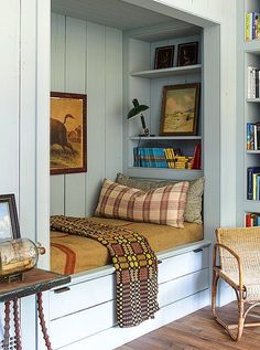 a room with bookshelves, chairs and pictures on the wall in it's corner