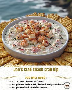 a bowl of crab dip with crackers on the side