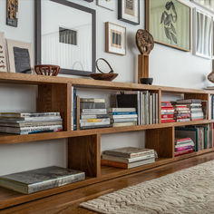 a bookshelf filled with lots of books on top of a hard wood floor