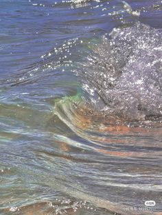 an ocean wave with small bubbles in the water