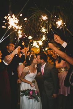 a bride and groom are surrounded by sparklers