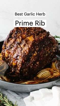 a roasting pan filled with meat covered in gravy next to rosemary sprigs