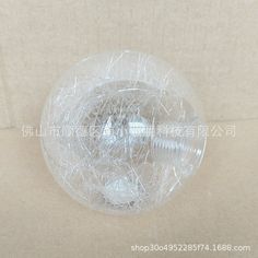 a clear plastic ball on a white surface with words written in english and chinese above it