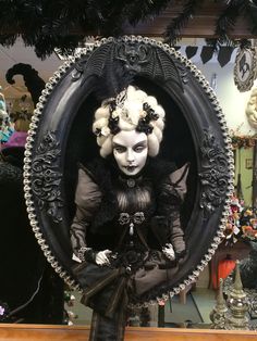 a creepy doll is sitting in an oval frame