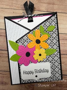 a birthday card with flowers on it and a tag hanging from the bottom that says happy birthday