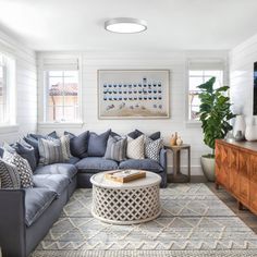 a living room filled with furniture and a flat screen tv on top of a wooden dresser