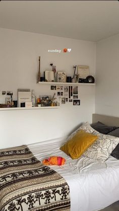 a bedroom with a bed, shelves and pictures on the wall above it's headboard