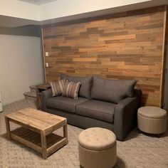 a living room filled with furniture and a wooden wall