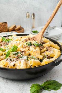 a skillet filled with pasta, meat and cheese on top of a white counter