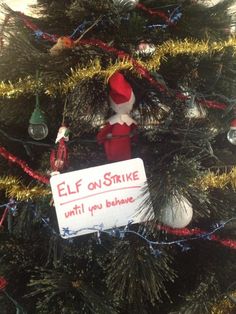 elf on strike sign hanging from christmas tree