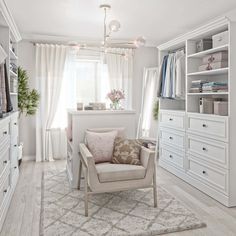 a living room with white furniture and lots of drawers