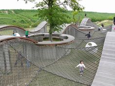 several children playing in an outdoor play area with trees and other things on the ground