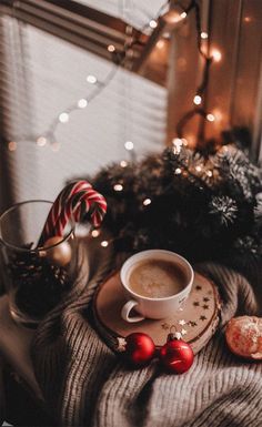 a cup of coffee and some candy canes on a table