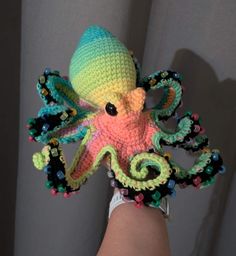 a crocheted octopus is being held in someone's hand