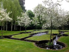 a garden with water features in the center and several trees around it on both sides