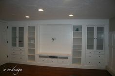 an empty room with built in cabinets and cupboards on the wall, next to a hardwood floor