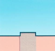 a skateboarder is doing a trick on the side of a building with a blue sky in the background