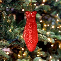 a red ornament hanging from a christmas tree