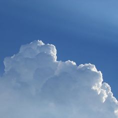 the airplane is flying high in the blue sky with white clouds behind it and an airplane on the right side